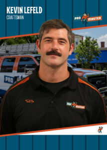 Kevin Lefeld | ProMaster Home Repair & Handyman Portrait of Kevin Lefeld, a Pro Master craftsman, in a black polo with orange accents, standing in front of a service van.