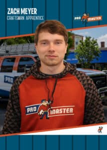 Portrait of Zach Meyer wearing a red and black Pro Master hoodie, standing in front of a van and storefront with the Pro Master branding in the background.