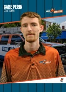 Portrait of Gabe Perin, craftsman for Pro Master, wearing an orange polo with the Pro Master logo, standing in front of service trucks.